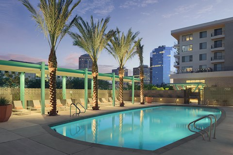 a swimming pool at a hotel with a city in the background