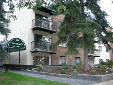 a apartment building with a tree in front of it