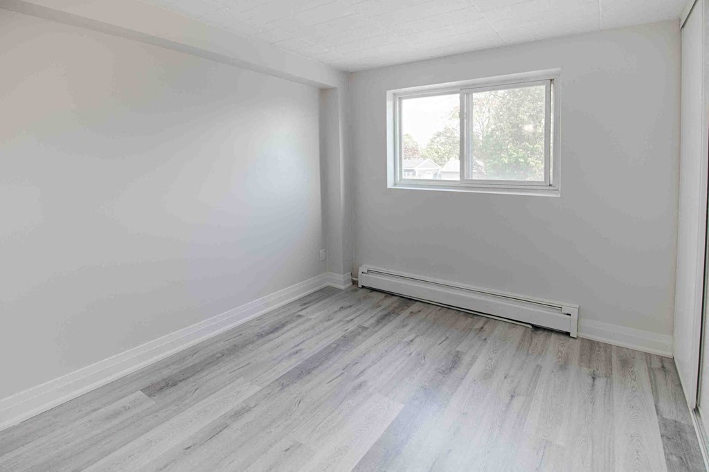 an empty room with white walls and a window