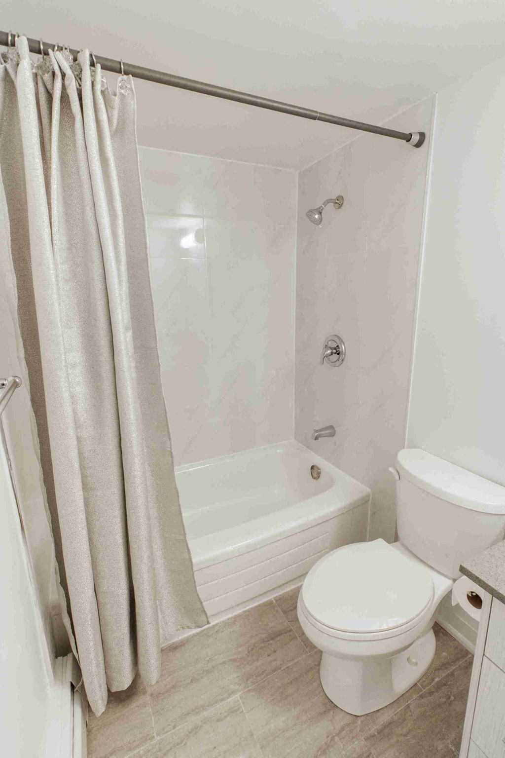 a bathroom with a toilet and a tub and a shower curtain