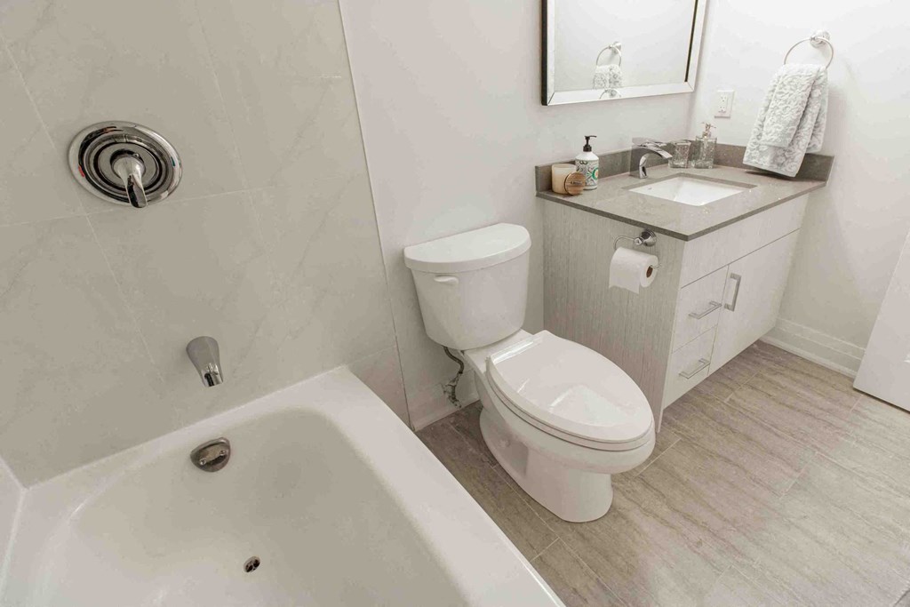 a bathroom with a toilet and a sink and a bath tub