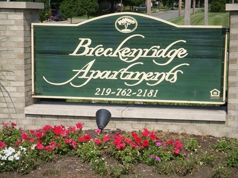 a sign at the front of a building with flowers