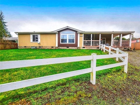 A house with a white fence in front of it.