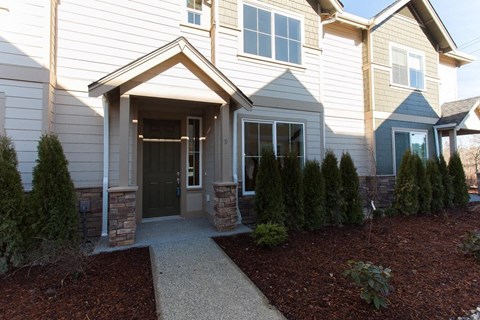 A house with a grey front door and a small garden.
