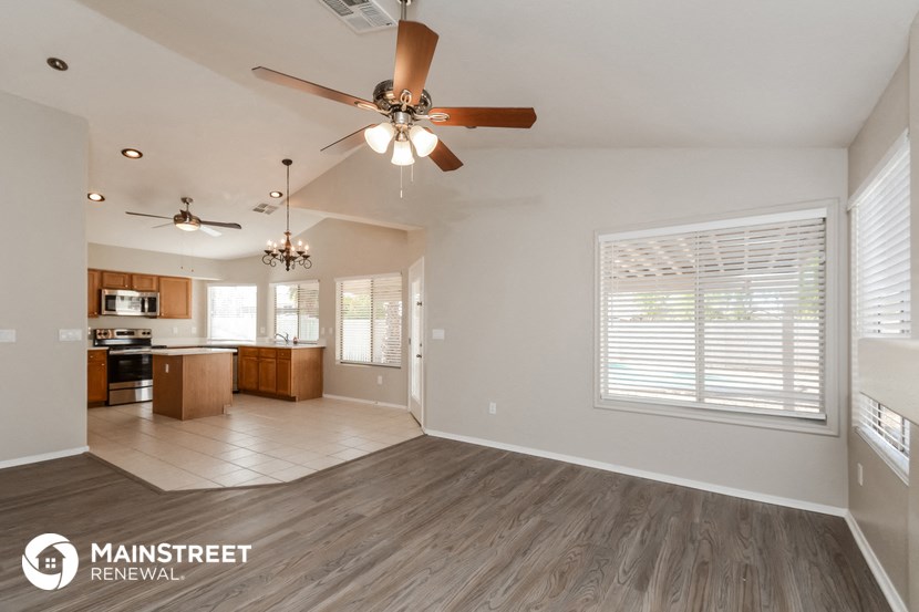 a living room with a ceiling fan and a kitchen