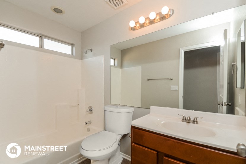 a bathroom with a sink toilet and a mirror