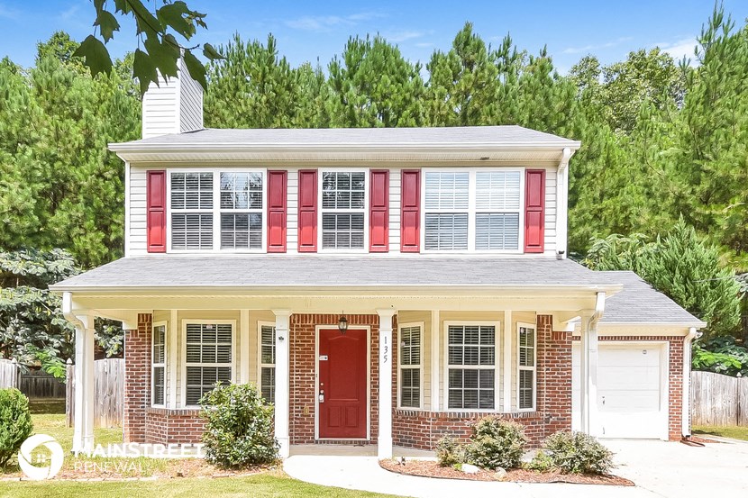a red brick house with red shutters and a red door