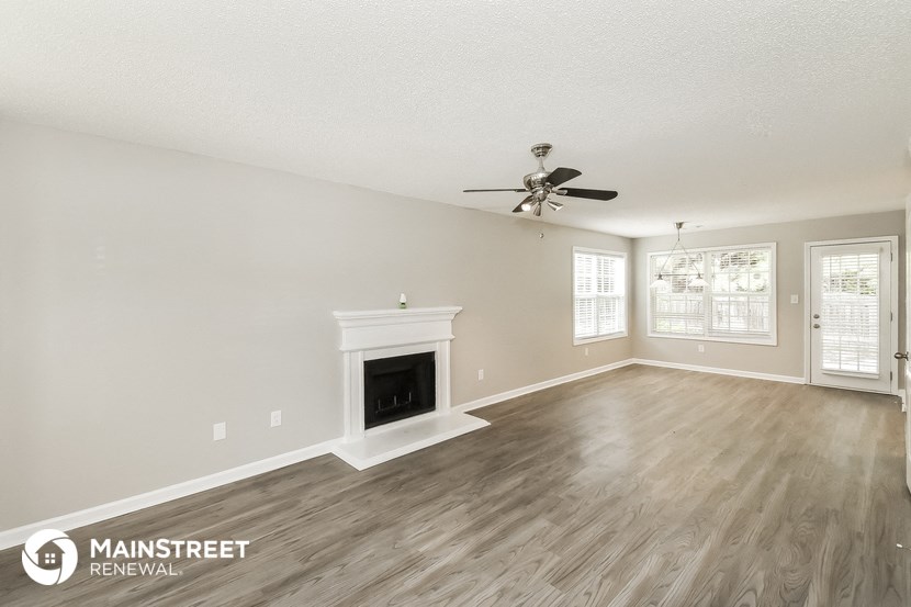 the living room with fireplace and ceiling fan