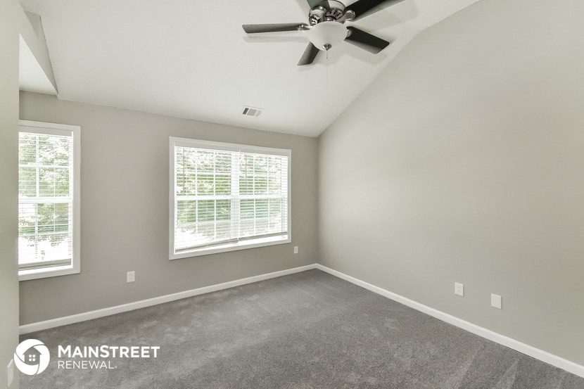 the master bedroom has a carpeted floor and a ceiling fan