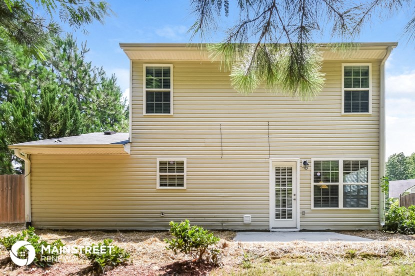 the front of a yellow house with a white door