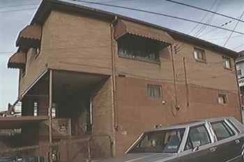 A brown building with a car parked in front.