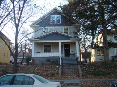 A house with a white car parked in front.
