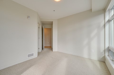 a living room with white walls and a large window