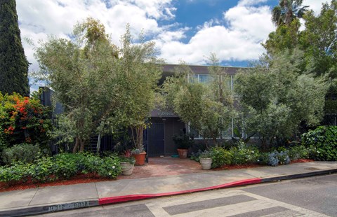 the front of a building with trees in front of it