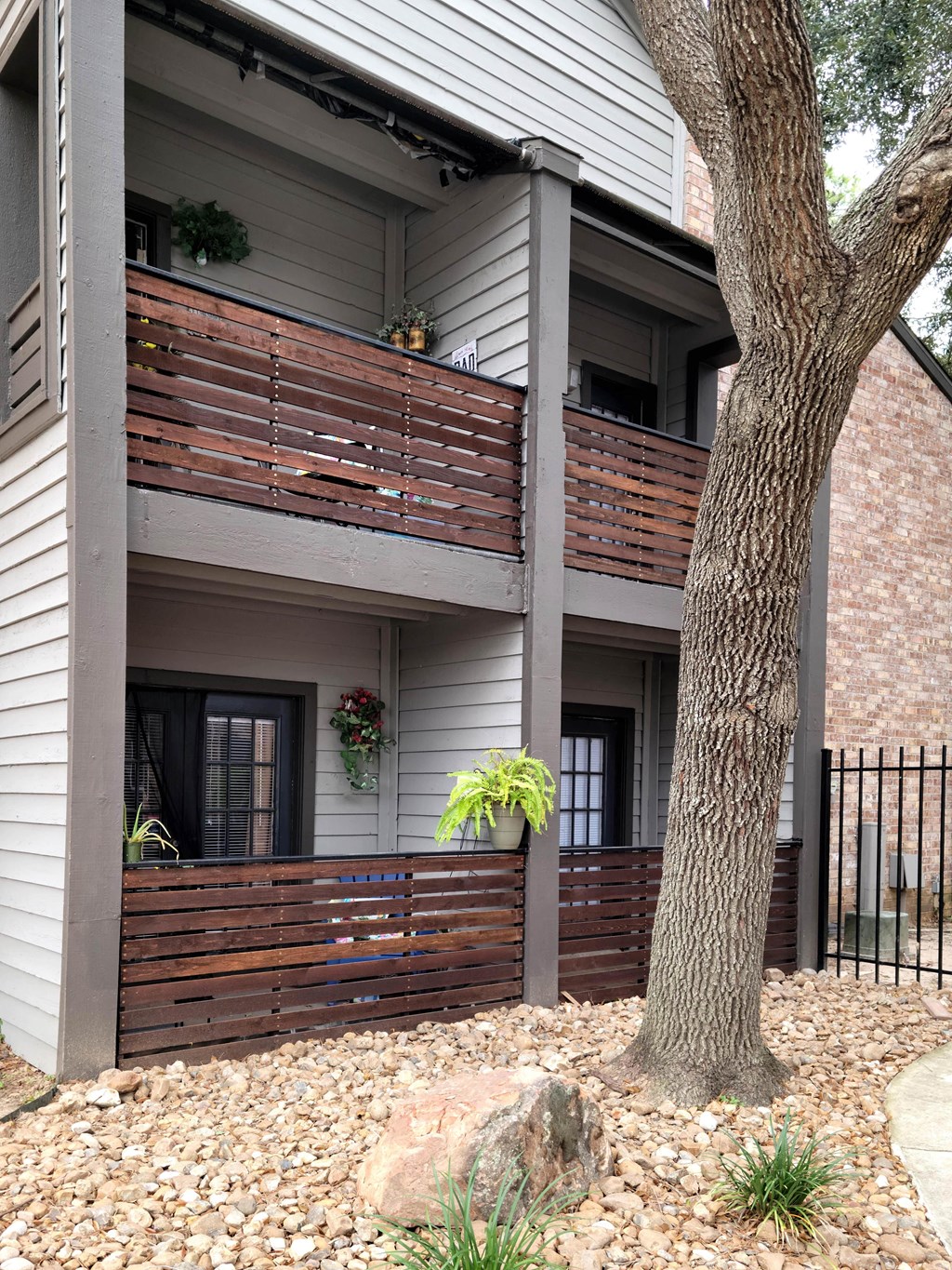 a view of the front of a house with a deck and a tree