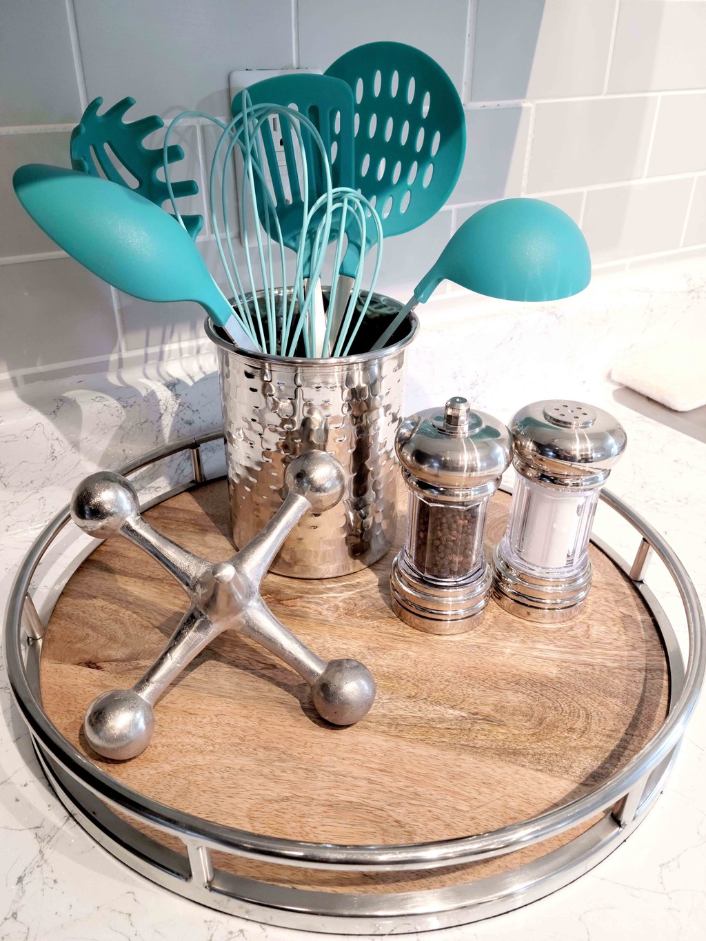 a wooden tray with spoons on top of a bathroom counter