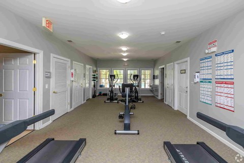A gym with treadmills, weights, and exercise equipment.