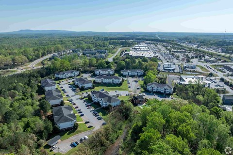 A bird's eye view of a residential area with houses and a parking lot.