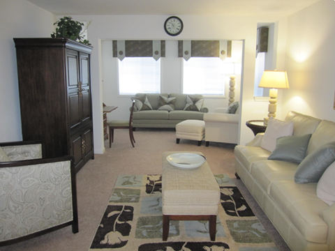 A living room with a couch, chair, and a table.