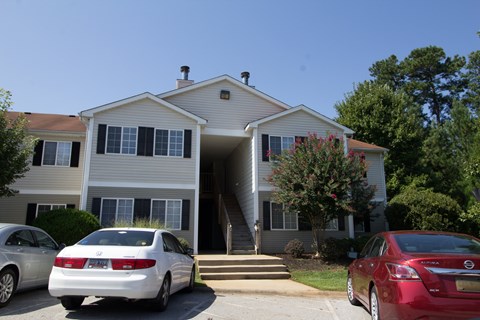 A white car is parked in front of a house.