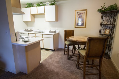 A kitchen with a table and chairs in the middle of the room.