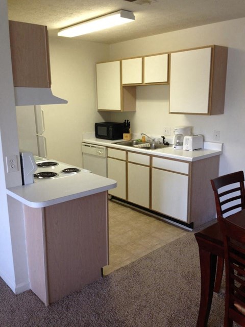 A small kitchen with a white counter top and a microwave.