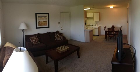 A living room with a brown couch and a white lamp.