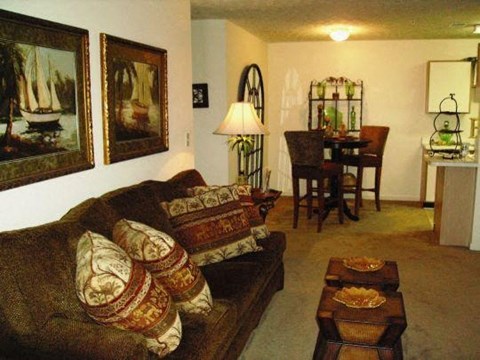 A living room with a couch, a table, and a lamp.