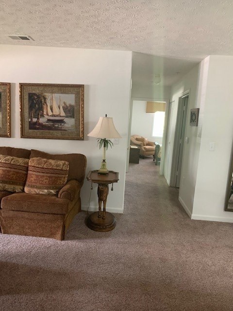 A living room with a couch, a lamp, and a painting on the wall.