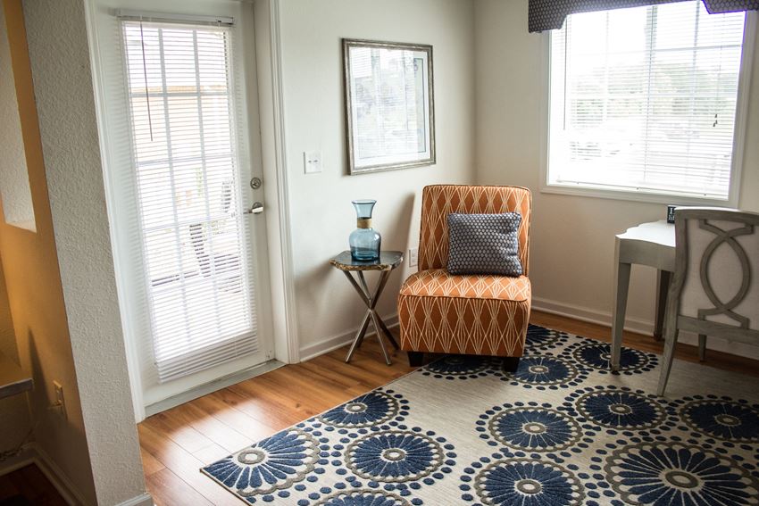 a living room with a chair and a rug on the floor