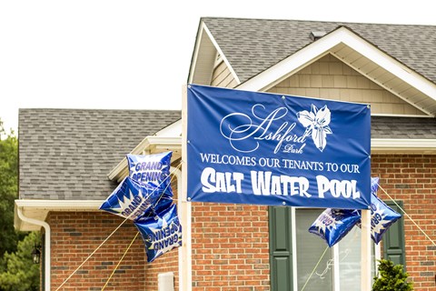 A blue banner with white text welcomes tenants to a salt water pool.