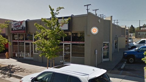 A white car is parked in front of a building with a sign that says "Silice Parlor".