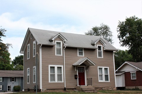 A house with a red door and a grey roof.