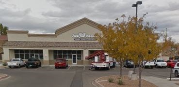 A storefront with a tree in front of it.