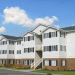 an apartment building with a blue sky in the background