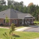 a brick house with a gray roof and a driveway