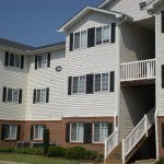 an apartment building with white siding and black windows