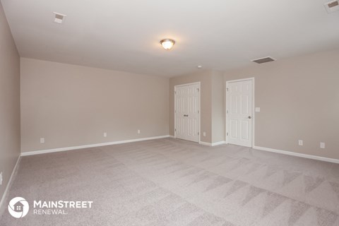 the spacious living room with white carpet and white doors