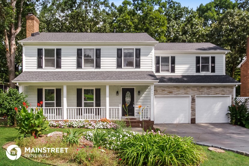 a white house with a porch and a white garage door