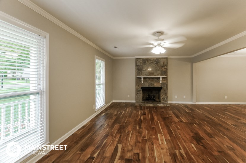 a living room with wood floors and a fireplace