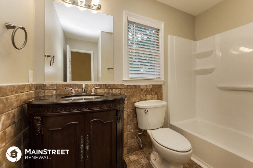 a bathroom with a toilet and a sink and a bath tub