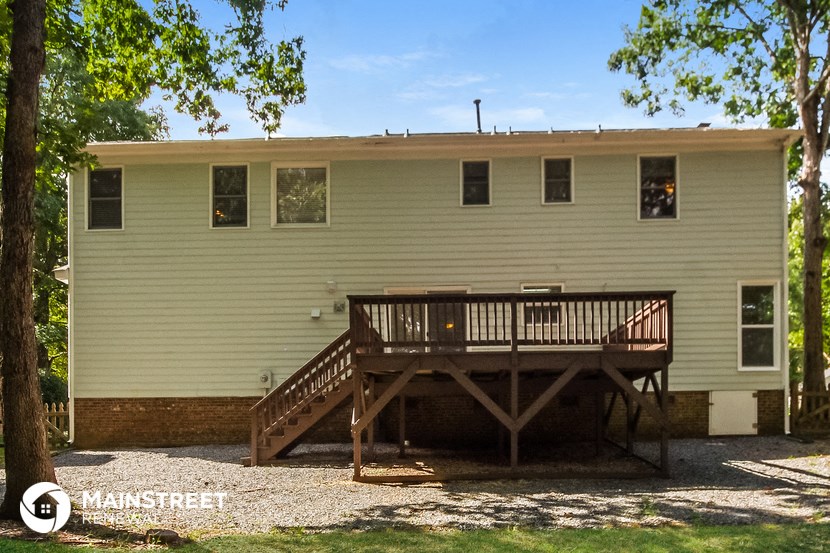 the back of the house with a wooden deck