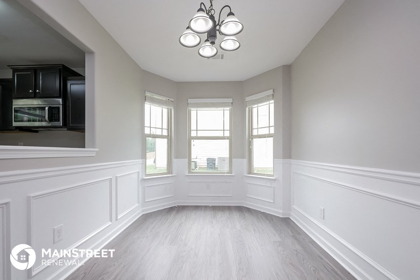 a dining room with white walls and a window