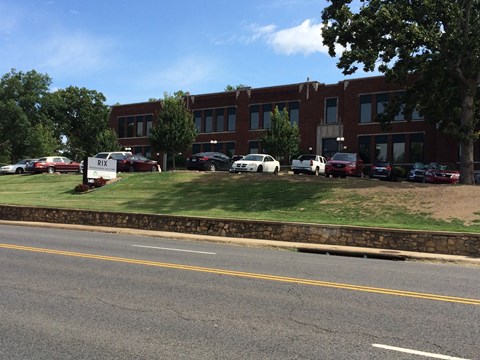 A parking lot with cars and a building in the background.