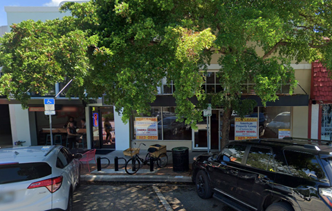 a city street with cars parked in front of a building