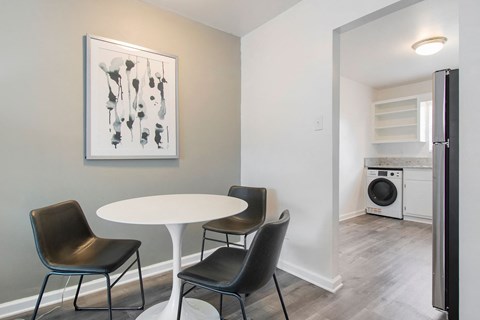 a kitchen with a white table and chairs and a washing machine