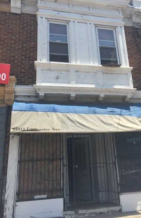 the front of a building with a tarp over the door and a window