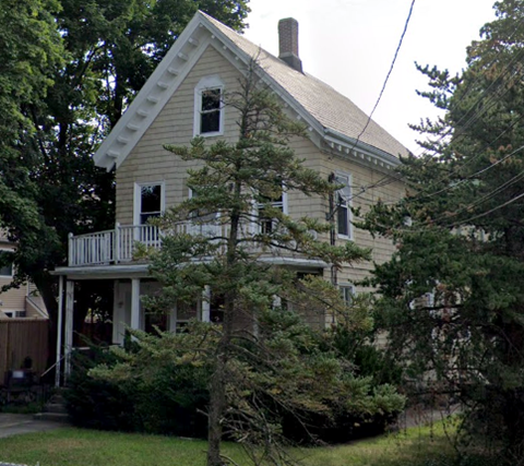 a white house with a tree in front of it