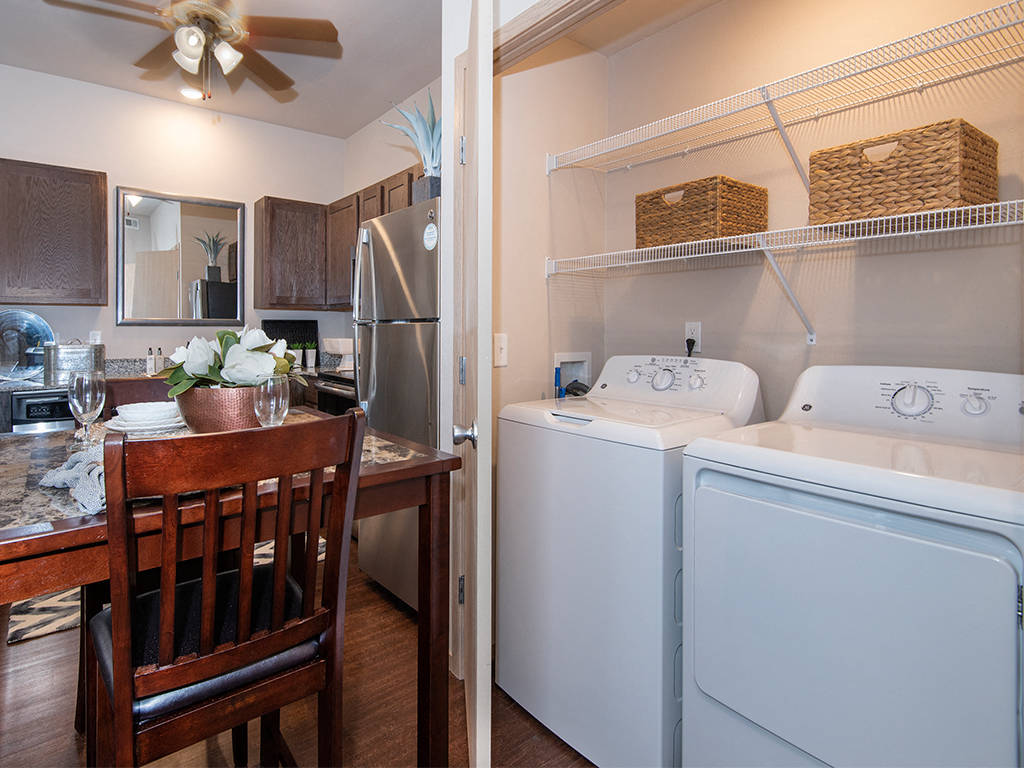 a kitchen and laundry room with a white washer and dryer and a table