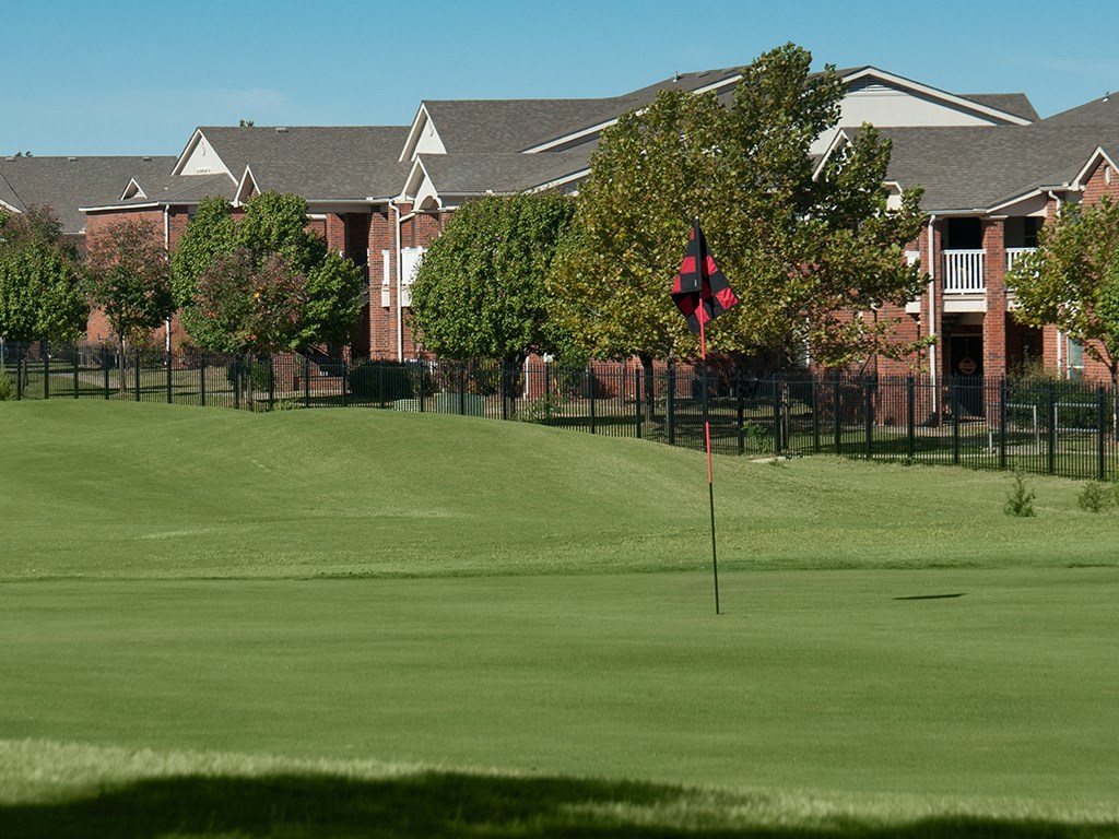 a view of a golf course with houses in the background